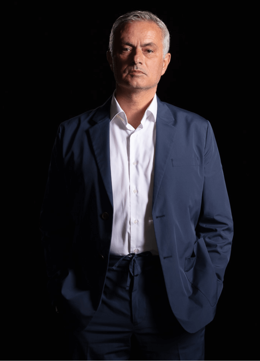 José Mourinho in suit standing with his hands in his pockets looking at the camera.